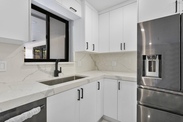 kitchen featuring white cabinetry, sink, dishwashing machine, stainless steel fridge with ice dispenser, and light stone countertops