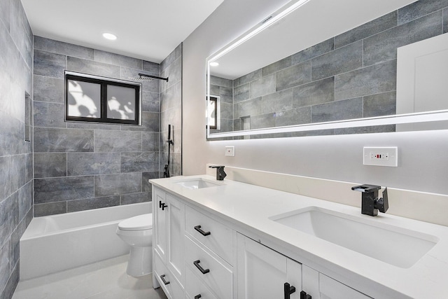 full bathroom featuring tiled shower / bath, vanity, and toilet