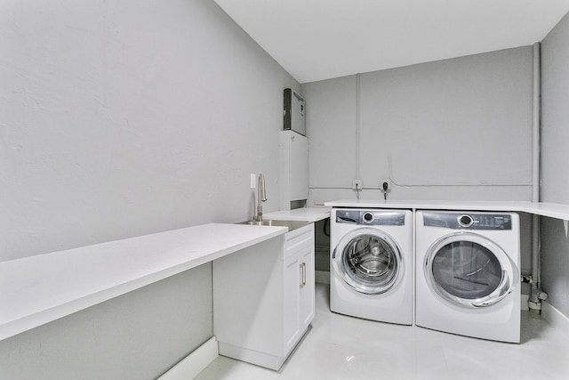 washroom featuring cabinets, sink, and washer and clothes dryer