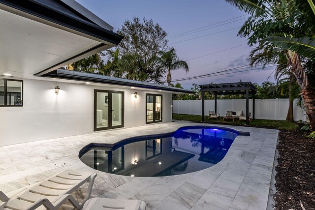 pool at dusk with a patio area