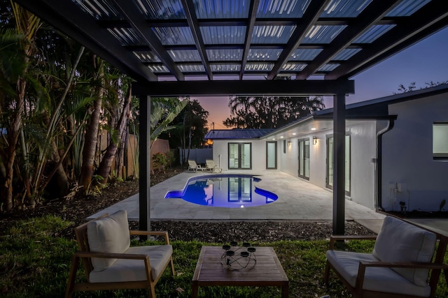 pool at dusk featuring a pergola and a patio area