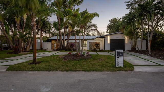 view of front of home featuring a garage and a lawn