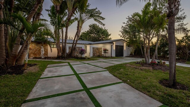 view of front facade featuring a garage and a lawn