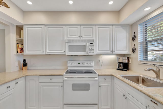 kitchen with white appliances, sink, and white cabinets