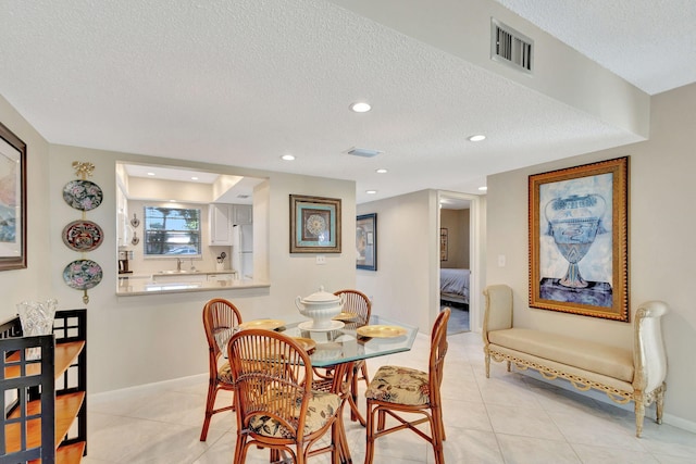 tiled dining area featuring a textured ceiling