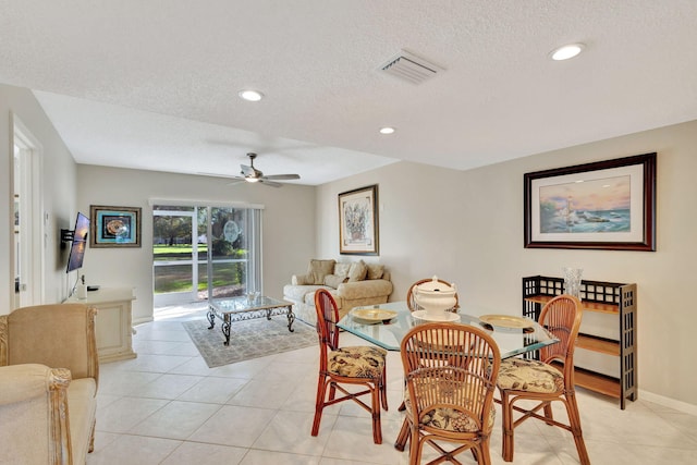 tiled dining room featuring ceiling fan and a textured ceiling