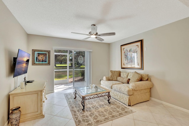 living room featuring ceiling fan, a textured ceiling, and light tile patterned flooring