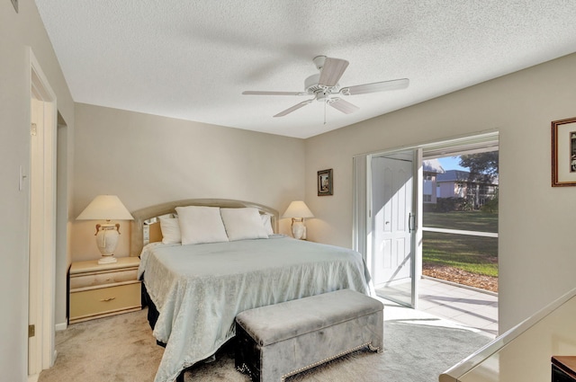 carpeted bedroom with ceiling fan, access to exterior, and a textured ceiling