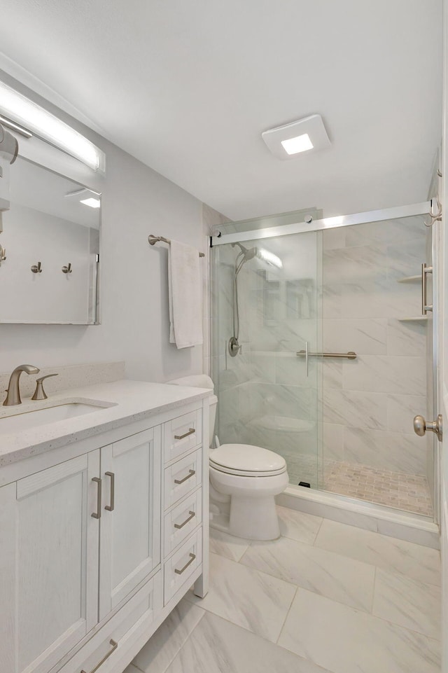 bathroom featuring vanity, toilet, and an enclosed shower