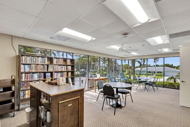 home office featuring light carpet, a paneled ceiling, and ceiling fan