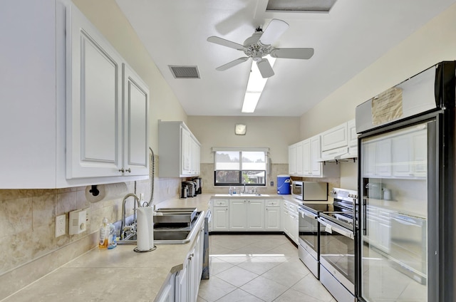 kitchen featuring light tile patterned floors, sink, appliances with stainless steel finishes, backsplash, and white cabinets