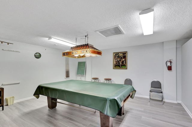 recreation room featuring hardwood / wood-style flooring, pool table, and a textured ceiling