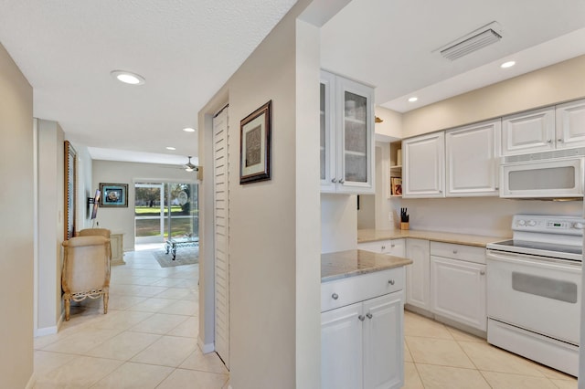 kitchen featuring light tile patterned flooring, white appliances, ceiling fan, and white cabinets