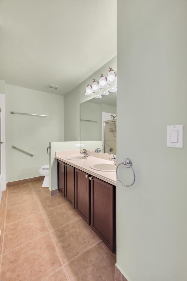 bathroom featuring vanity, a shower, tile patterned floors, and toilet