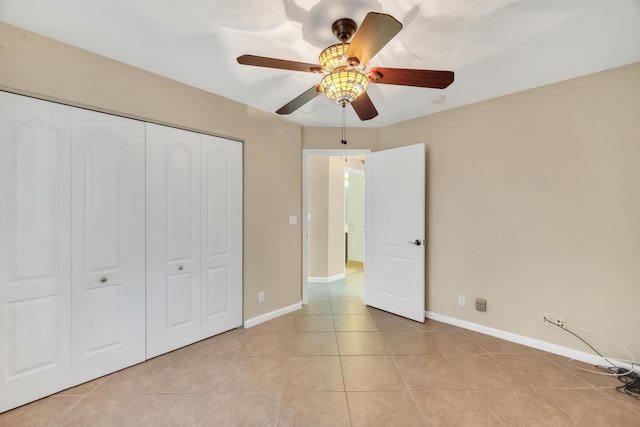 unfurnished bedroom with ceiling fan, a closet, and light tile patterned floors