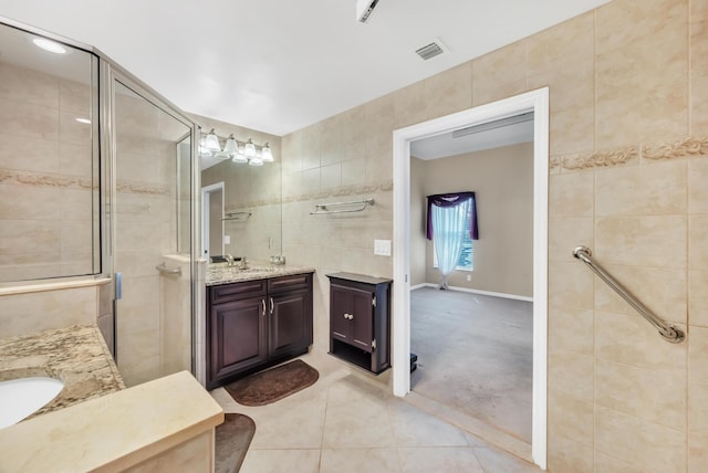 bathroom with vanity, tile walls, tile patterned floors, and walk in shower