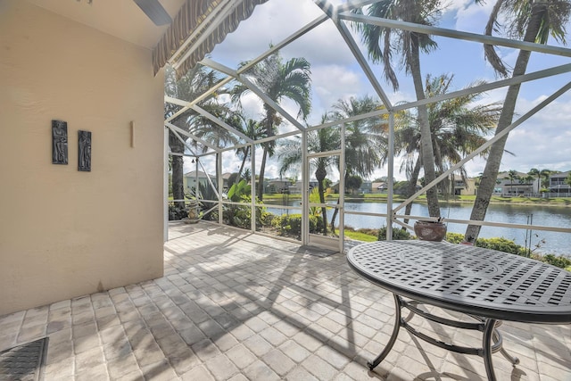 sunroom featuring a water view