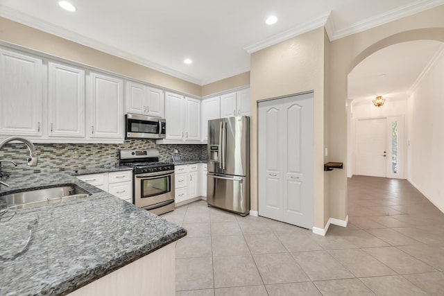 kitchen with sink, crown molding, light tile patterned floors, stainless steel appliances, and white cabinets