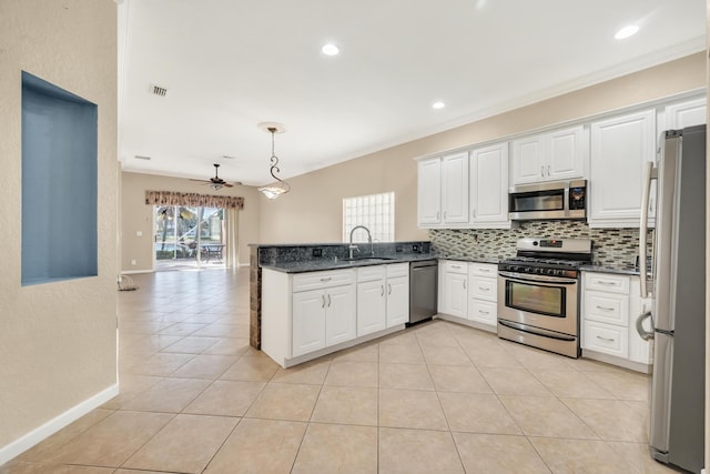 kitchen with sink, white cabinetry, tasteful backsplash, decorative light fixtures, and appliances with stainless steel finishes