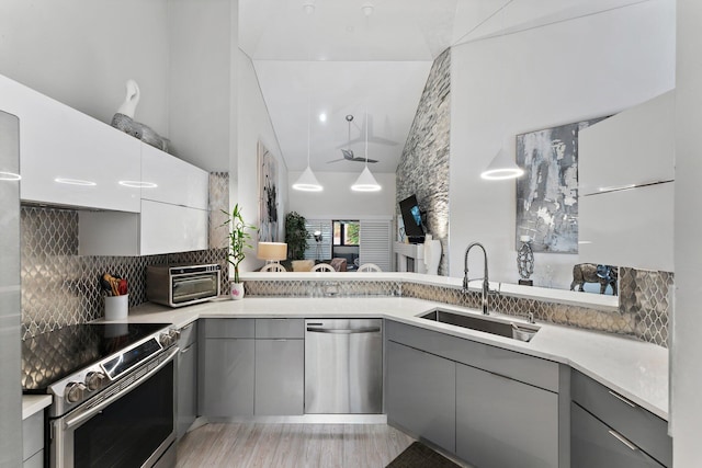 kitchen with gray cabinetry, sink, tasteful backsplash, and appliances with stainless steel finishes