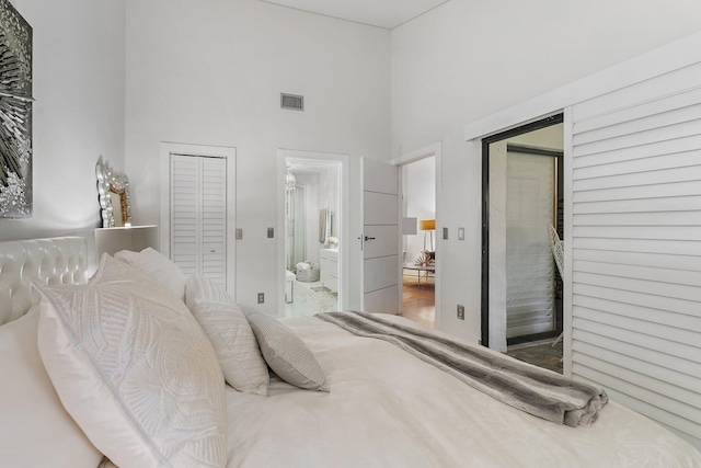 bedroom with ensuite bath and a high ceiling