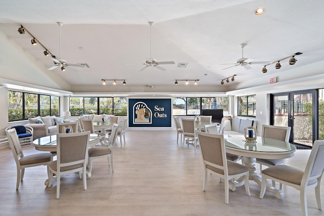 dining area with lofted ceiling, light hardwood / wood-style flooring, french doors, and a healthy amount of sunlight