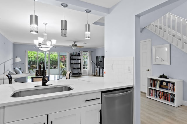 kitchen with sink, stainless steel dishwasher, pendant lighting, light stone countertops, and white cabinets