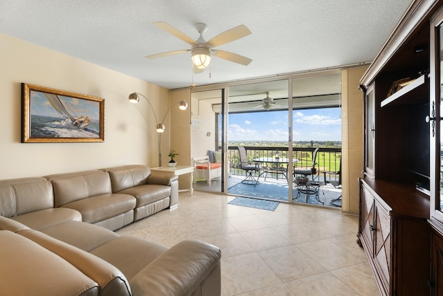 tiled living room with a textured ceiling, floor to ceiling windows, and ceiling fan