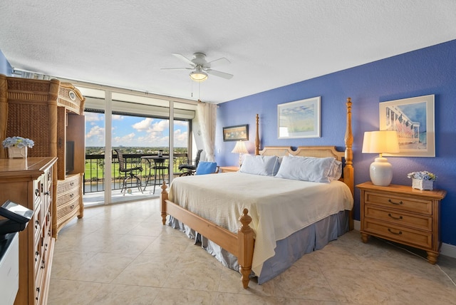 bedroom featuring ceiling fan, a textured ceiling, access to exterior, and a wall of windows