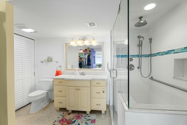 bathroom with vanity, a shower with door, and toilet