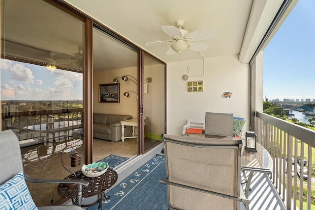 balcony featuring a water view and ceiling fan