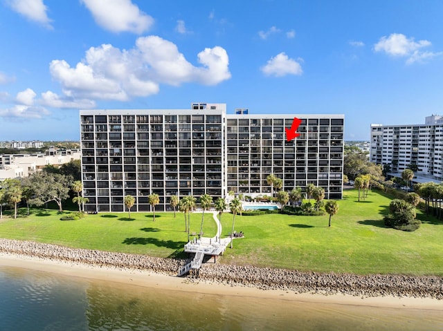 view of building exterior featuring a water view and a beach view