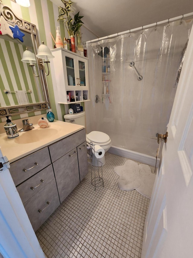 bathroom featuring tile patterned flooring, vanity, a shower with shower curtain, and toilet