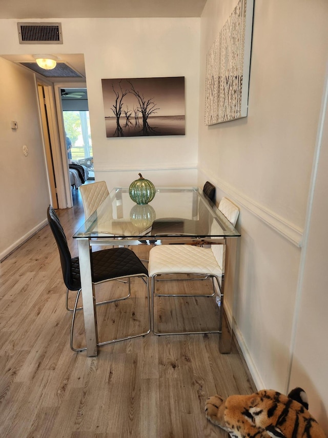 dining room with baseboards, visible vents, and wood finished floors