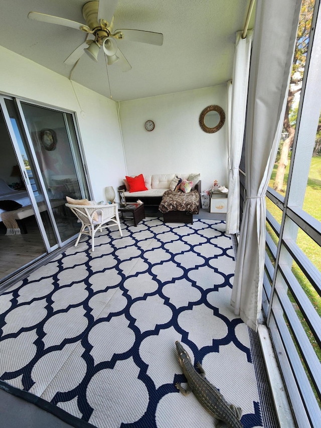 unfurnished sunroom featuring a ceiling fan