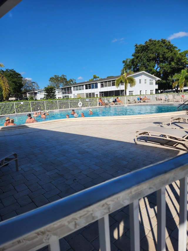 pool featuring fence and a patio