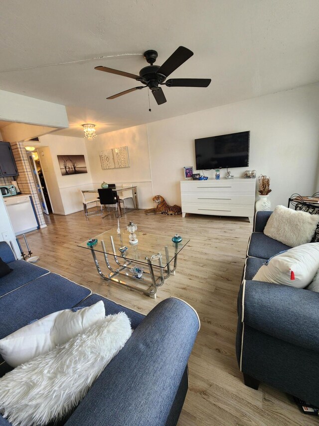 kitchen featuring tasteful backsplash, white appliances, hanging light fixtures, and light wood-type flooring