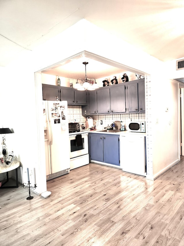 kitchen featuring light wood-type flooring, white appliances, tasteful backsplash, and gray cabinetry