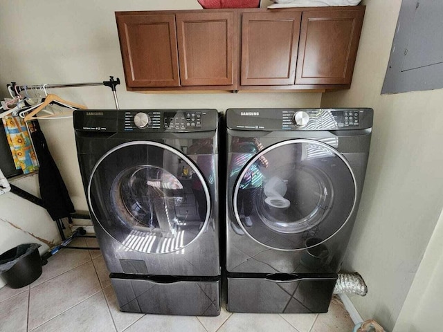 clothes washing area with cabinets, separate washer and dryer, light tile patterned floors, and electric panel