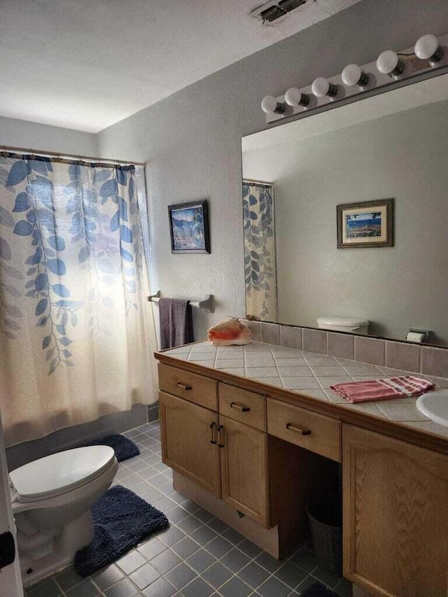 bathroom featuring tile patterned flooring, vanity, a shower with curtain, and toilet