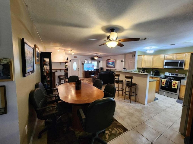 tiled dining area featuring ceiling fan and a textured ceiling