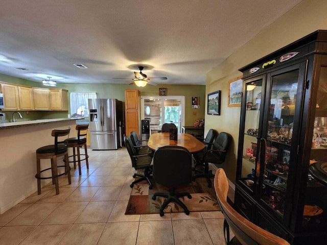 tiled dining room featuring a textured ceiling