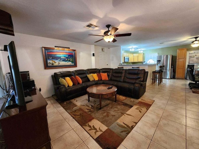 tiled living room featuring a textured ceiling and ceiling fan