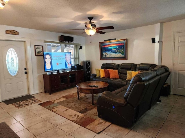 living room featuring ceiling fan, a textured ceiling, and light tile patterned floors