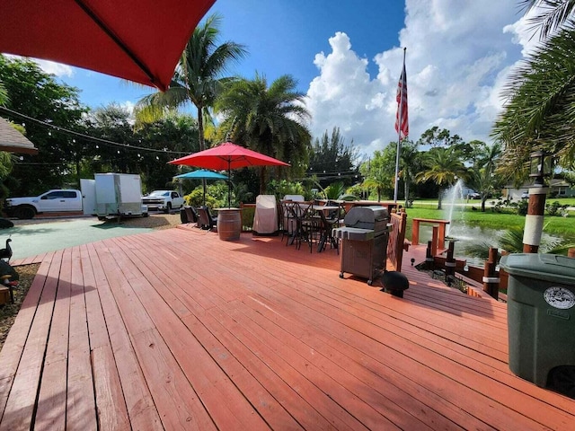 wooden terrace with grilling area and a water view