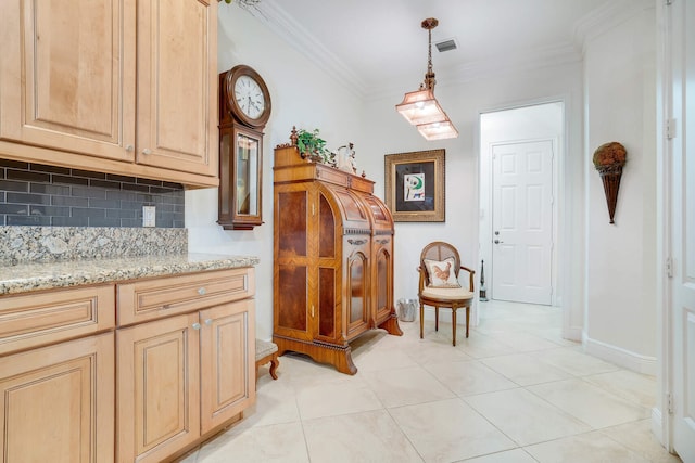 living area with light tile patterned floors and ornamental molding