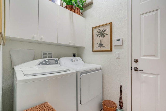 laundry room with washer and clothes dryer and cabinets