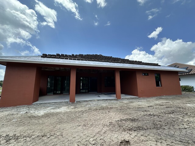 back of property with a patio and stucco siding
