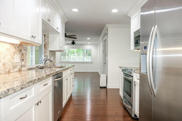 kitchen featuring white cabinetry, backsplash, light stone counters, stainless steel appliances, and dark wood-type flooring