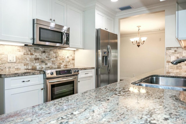 kitchen with sink, light stone countertops, white cabinets, and appliances with stainless steel finishes